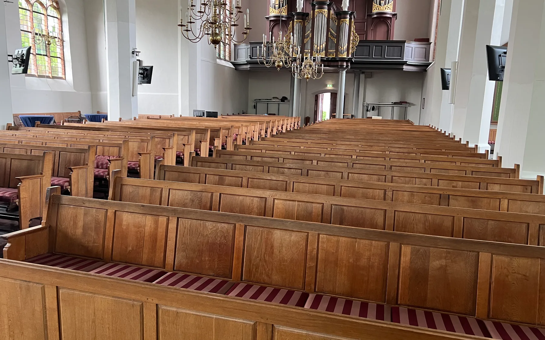 Church interior with wooden pews and heated church bench cushions by Warmpi